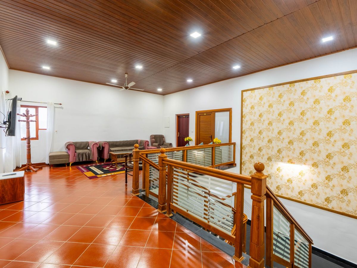 Guest lounge with sofas and a wooden staircase at Zen Garden Vagamon