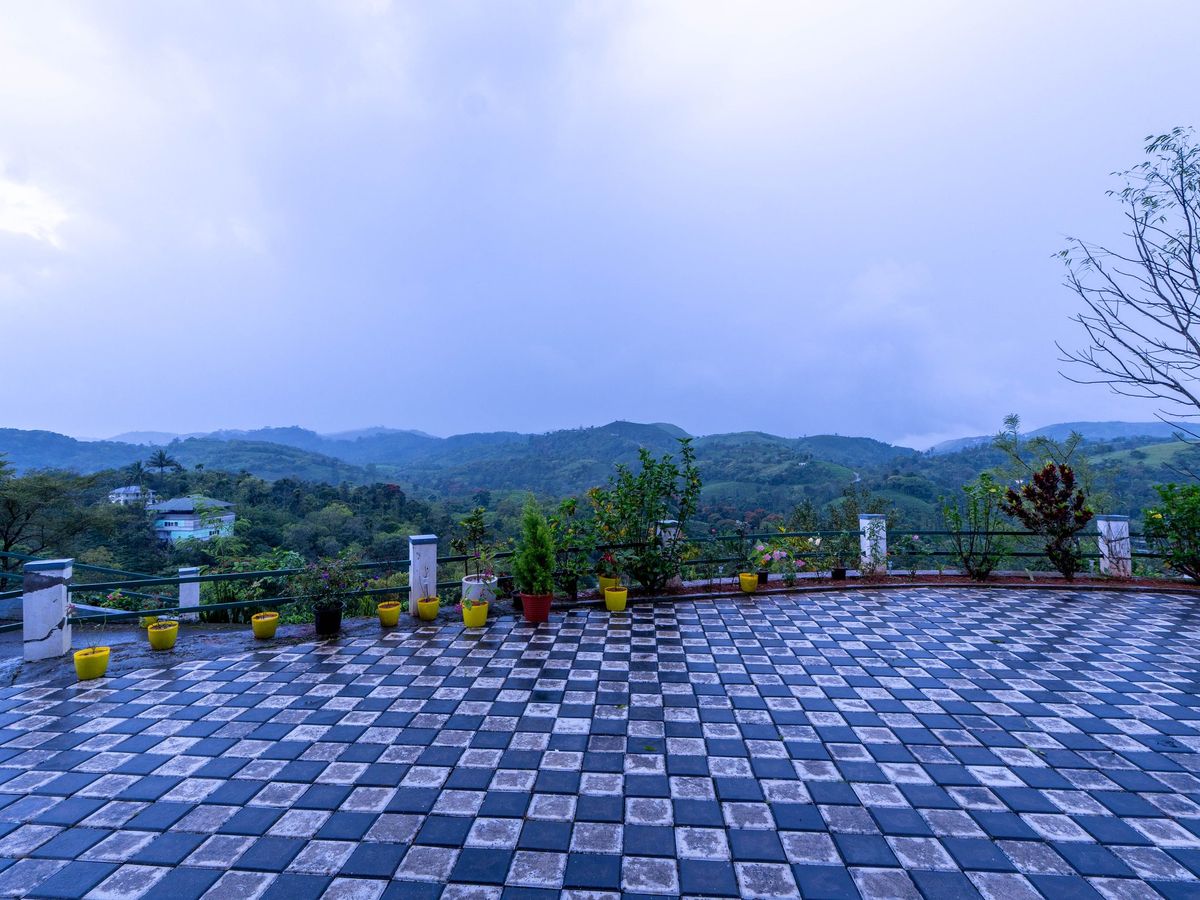 Open tiled terrace at Zen Garden Vagamon looking out over green hills